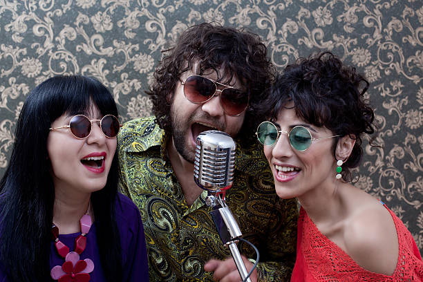 istock Three friends in seventies style singing on old fashioned microphone 182033517