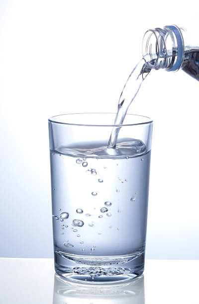 istock A glass of water being poured on a white background 182033566