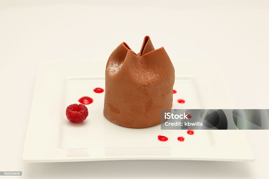 Corona de chocolate sobre plato cuadrado con frambuesa y jus - Foto de stock de Lujo libre de derechos
