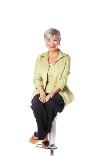 Portrait of confidence businesswoman sitting against white background