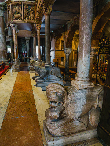 MODENA, ITALY - JUNE 22, 2023: Columns in the intricately decorated crypt of the Metropolitan Cathedral of Saint Mary of the Assumption and Saint Geminianus in Modena,Italy with sculptures of lions at the bottom