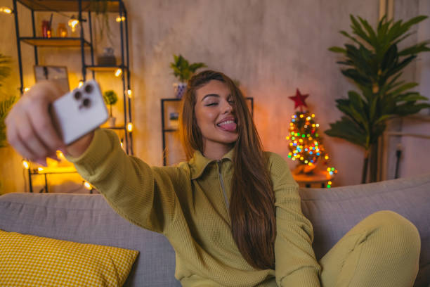 istock Young woman using her phone to take selfies at home 1820370158
