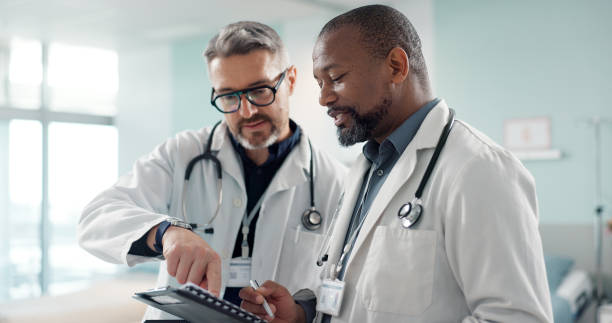 istock Doctors, men and tablet for team discussion, planning and advice with innovation, research or problem solving. Diversity, medical partnership and talk with notebook, digital touchscreen and report 1820379325