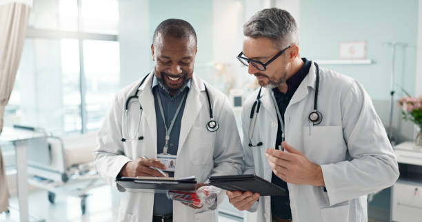 istock Doctors, men and tablet for team discussion, planning and advice with innovation, research or problem solving. Diversity, medical partnership and talk with notebook, digital touchscreen and report 1820379334