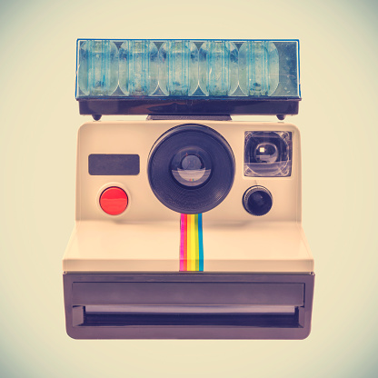 Retro styled image of an ancient instant photo camera with flash