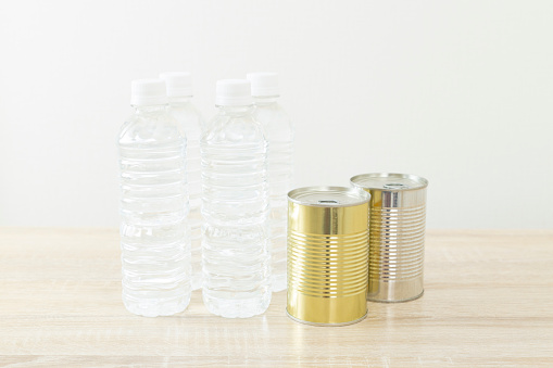 Canned food and drinking water lined up on the desk.