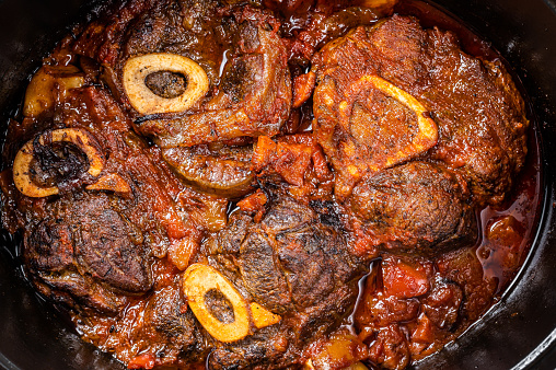 Osso buco cross cut veal shank braised with tomatoes and spices, beef meat Ossobuco. White background. Top view.