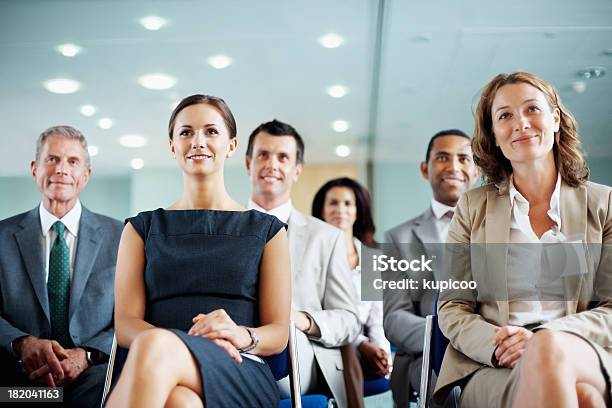 Foto de Negócios Bem Sucedidos Homens E Mulheres Sentado Em Uma Sala De Conferências e mais fotos de stock de Seminário - Reunião