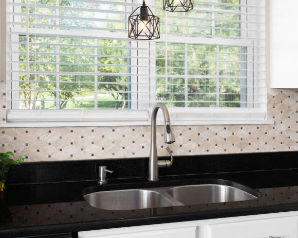 istock A kitchen sink detail with a stone backsplash and black countertop. 1820413756