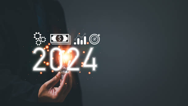 Startup business concept. Man holding a light bulb. With a clear vision and strategic plan, a determined businessman navigates the trends of 2024, paving the way for a prosperous future.
