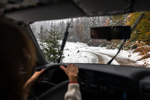 Skilled Female Driver Tackles Slippery, Icy Roads in a Snowfall, Maneuvering Through Unpredictable Weather Conditions
