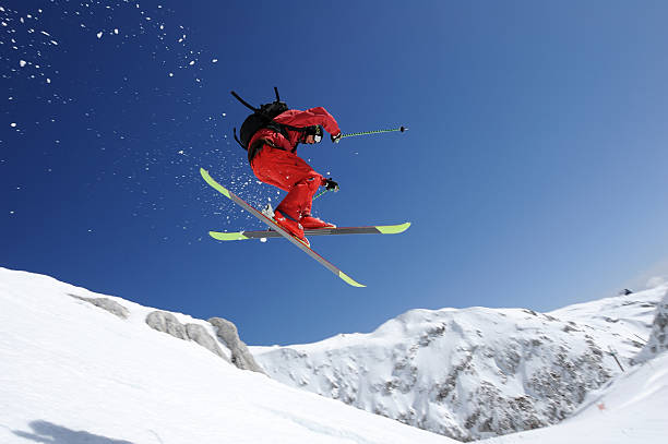 Extreme free ride skier in mid air Side view of young male free ride skier in mid-air against the blue sky extreme skiing stock pictures, royalty-free photos & images