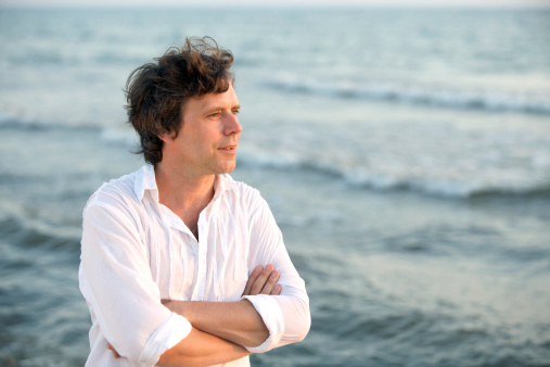 Happy man by the sea looking at the water