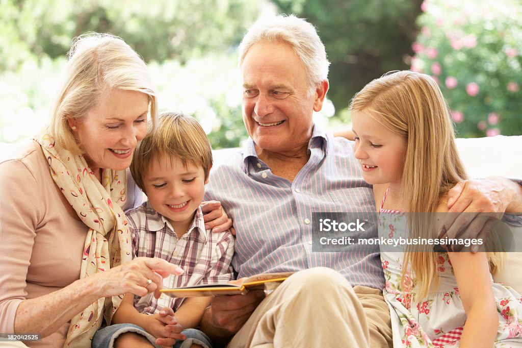 Portrait de grands-parents petits-enfants sur la lecture de canapé - Photo de Grand-parent libre de droits