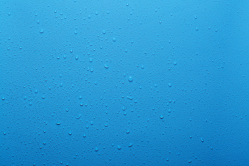 Water drops on blue background and plastic surface
