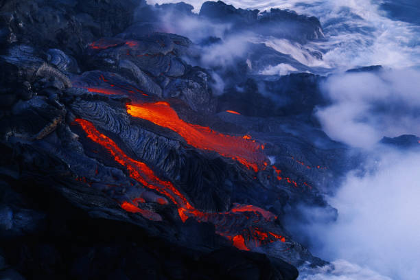 Lava flow in Hawaii flowing into the ocean "Lava flow from Kilauea  Hawaii flows into the steaming Pacific  ocean, Big Island" hawaii volcanoes national park photos stock pictures, royalty-free photos & images
