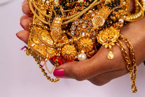 istock gold jewelery in hand isolated on white background. 1820442967