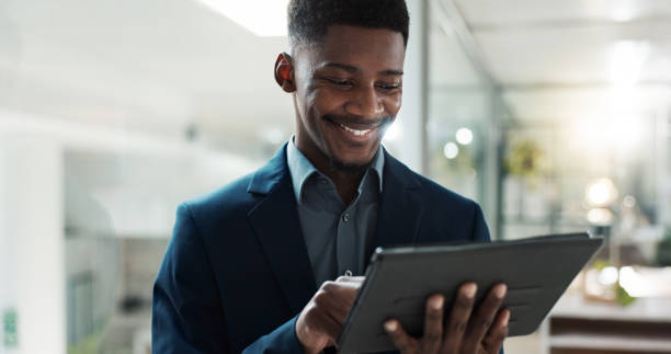 istock Tablet, networking and businessman in the office typing a message on the internet or mobile app. Digital technology, chatting and African male lawyer scroll on social media or website in workplace. 1820446227