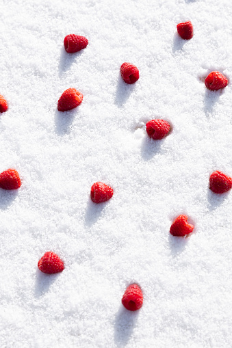 fresh raspberries on winter snow blanket