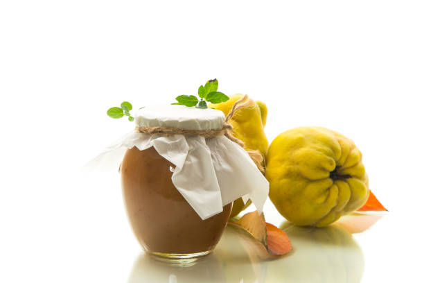 istock Ripe quince fruit with jam in a glass jar isolated on a white background. 1820468329