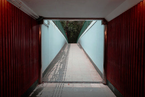 Walkway in the middle of the tunnel with red wooden wall.