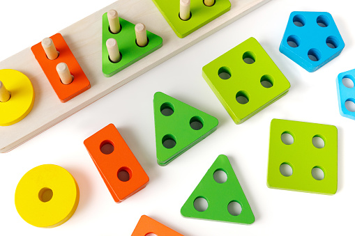 Primary age children's wooden educational puzzle toy for the development of finger motor skills and logic, on a white background.