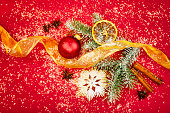 Christmas decoration with ribbon and fir branch on red background