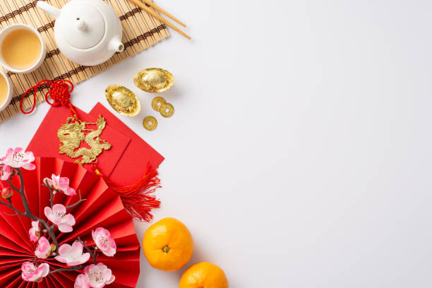 istock Immerse in richness of Chinese New Year with exquisite table setting. Top-view image showcasing traditional fan, green tea ceremony set, Feng Shui artifacts, sakura, etc, white backdrop for advert 1820492621