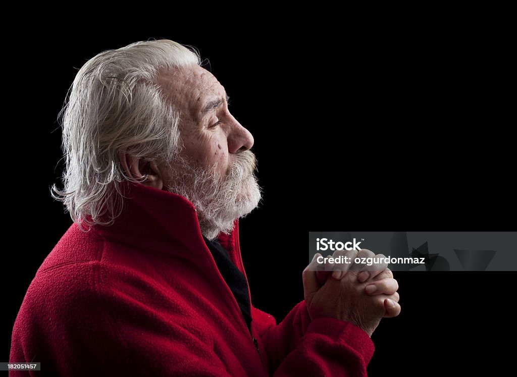 Praying old man "Side view of a senior man praying, with copy space to the right." Aspirations Stock Photo