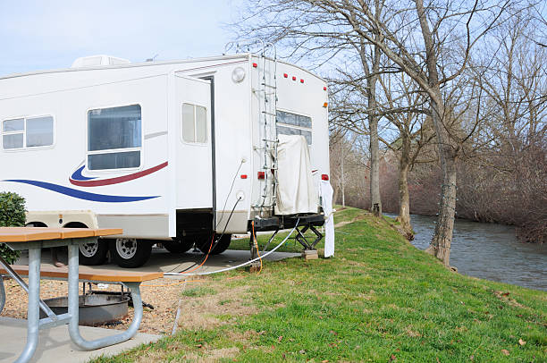 istock Recreational vehicle in campsite by creek 182051606