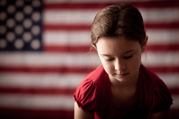 triste et déprimé jeune fille, devant le drapeau américain - child grief mourner disappointment photos et images de collection