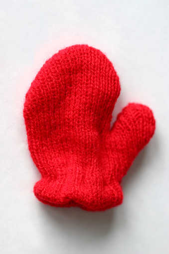 A close up of a red mitten.