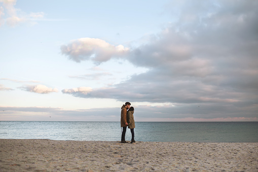 Shot of a cheerful young woman being carried piggyback by her boyfriend at the beach