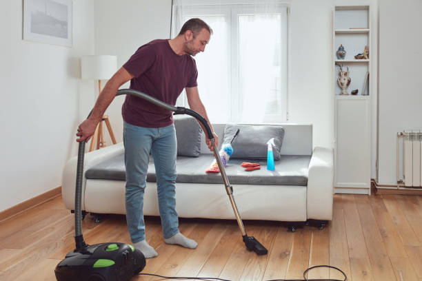 istock Man cleaning apartment with vacuum cleaner. 1820526036