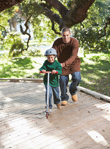 hispânica pai e filho de scooter do parque - sc0526 - fotografias e filmes do acervo