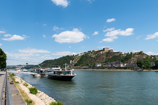 Recreational vessel on the river Rhine and the aerial cableway over the Rhine to the Ehrenbreitstein Fortress in Koblenz in Germany.