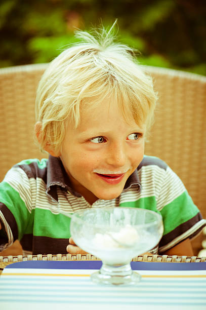 istock Kid with a milk moustache eating ice cream. 182053021