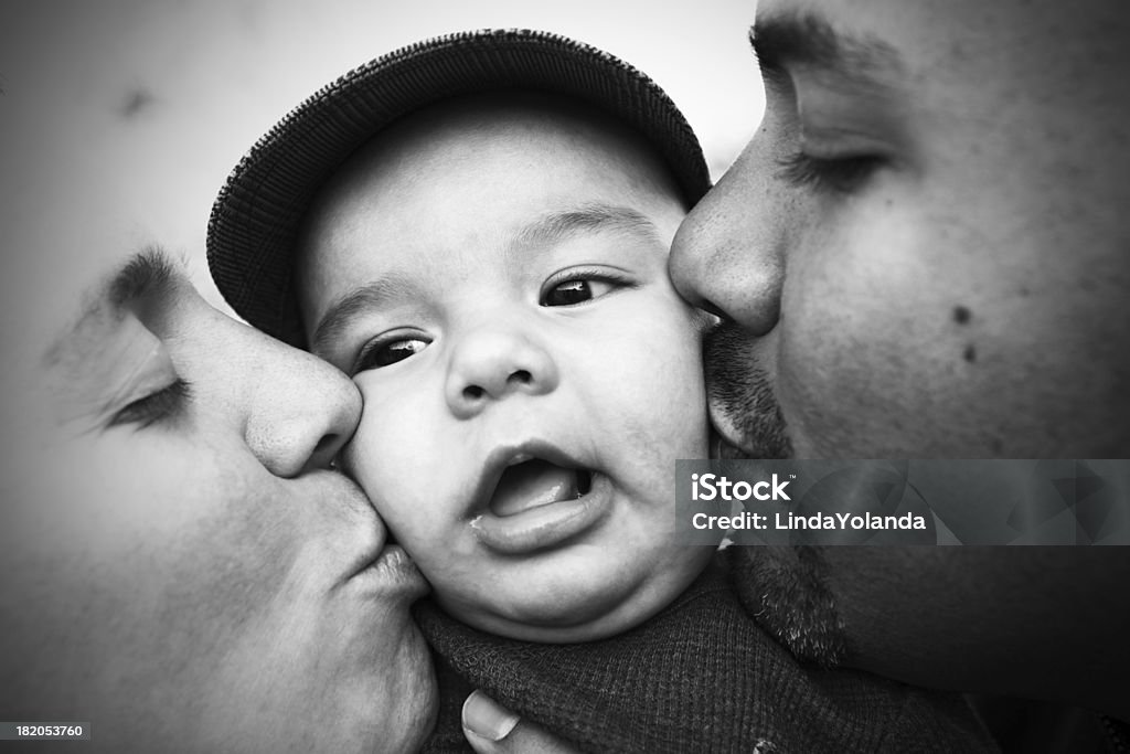 Mom and Dad Kissing Baby A mom and dad kiss their baby boy's cheeks. Shot with a Canon 5D Mark II. Black And White Stock Photo