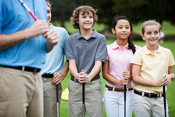 grupo de niños en el campo de práctica de golf con instructor - sc0529 fotografías e imágenes de stock