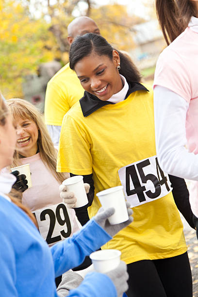 istock Race runners receiving drinks from volunteers during an event 182053823