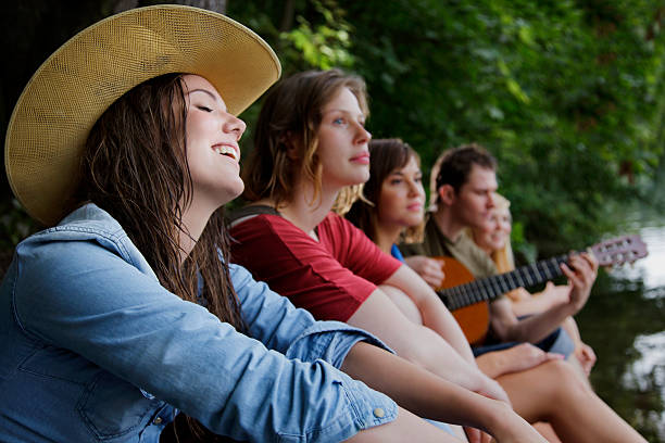 istock Friends on a Camping Trip Singing and Playing Guitar 182054097