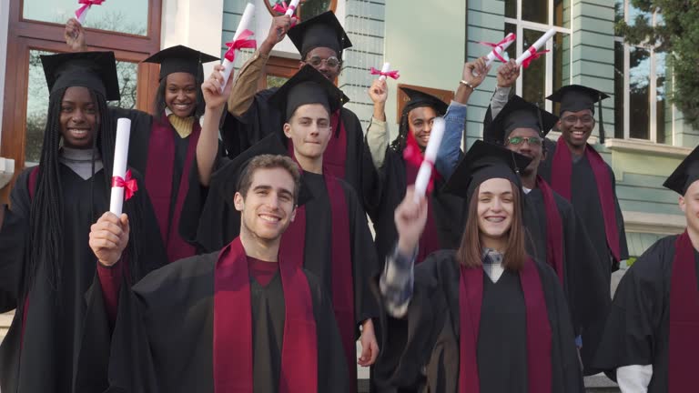 Happy graduates waving their diplomas