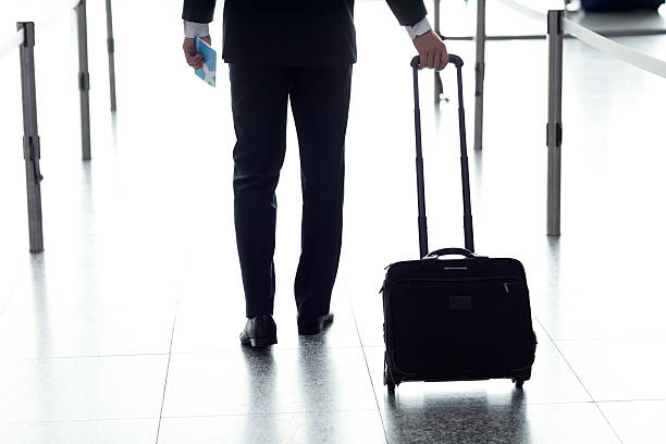 istock Businessman Pulling Luggage at Airport. 182054179