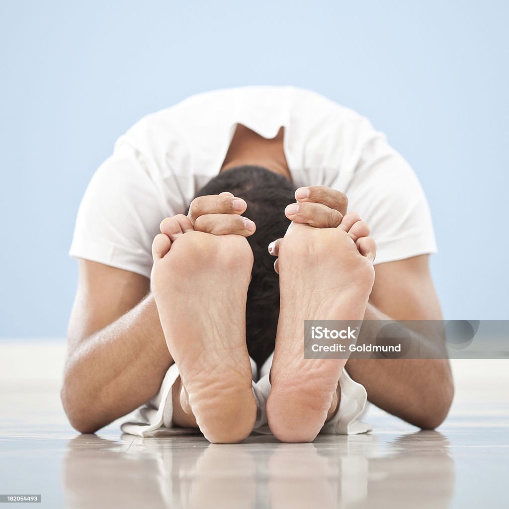 Yoga: Paschimottanasana Caucasian man performing Paschimottanasana yoga posture. 40-49 Years Stock Photo