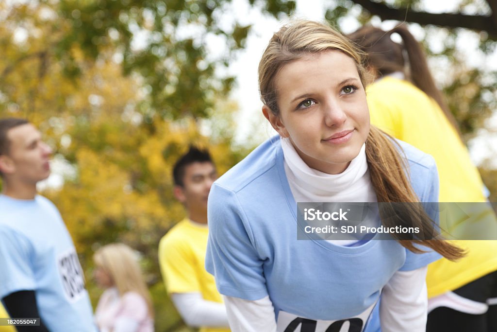 Teenage girl leaning over at a charity race Teenage girl leaning over at a charity race. Running Stock Photo