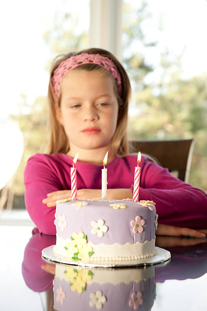 istock sad girl with birthday's cake 182055052