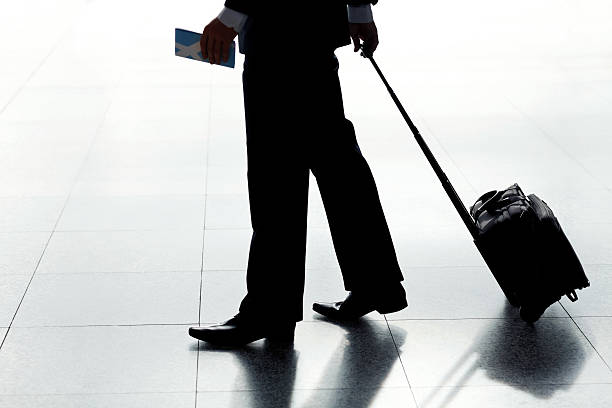 istock Businessman Pulling Luggage at an Airport 182055229