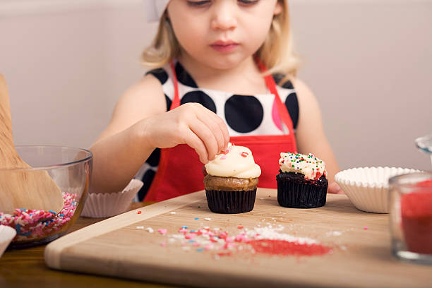 istock Cupcake Decorating by Little Girl Close Up Image 182055365