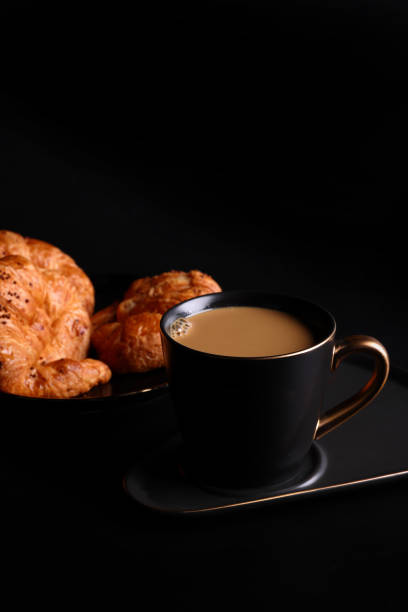 istock Hot latte coffee with Croissant coffee break isolated in black background 1820556396