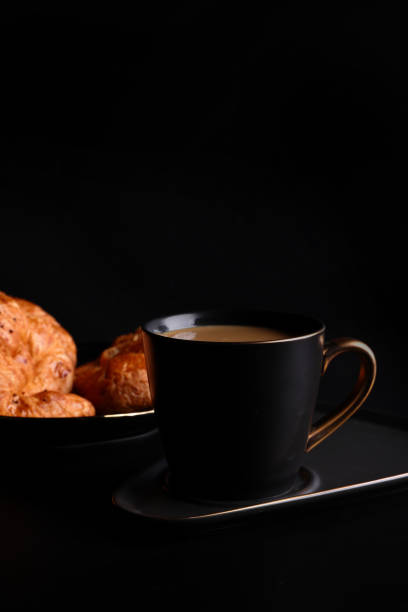 istock Hot latte coffee with Croissant coffee break isolated in black background 1820556582